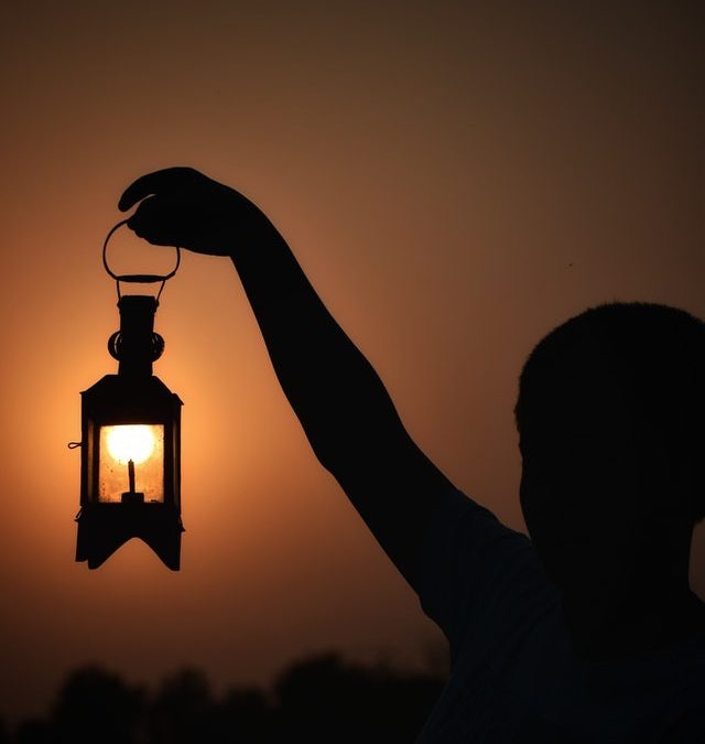 Holding up a lantern in the dark.