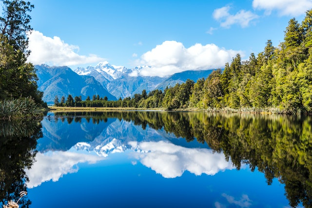 A view over a crystal clear lake to snow-capped mountains