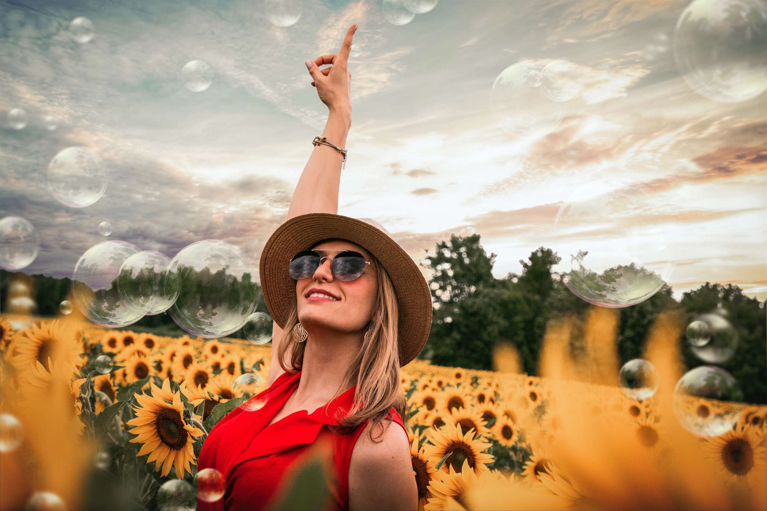 A woman celebrating in a field of sunflowers.