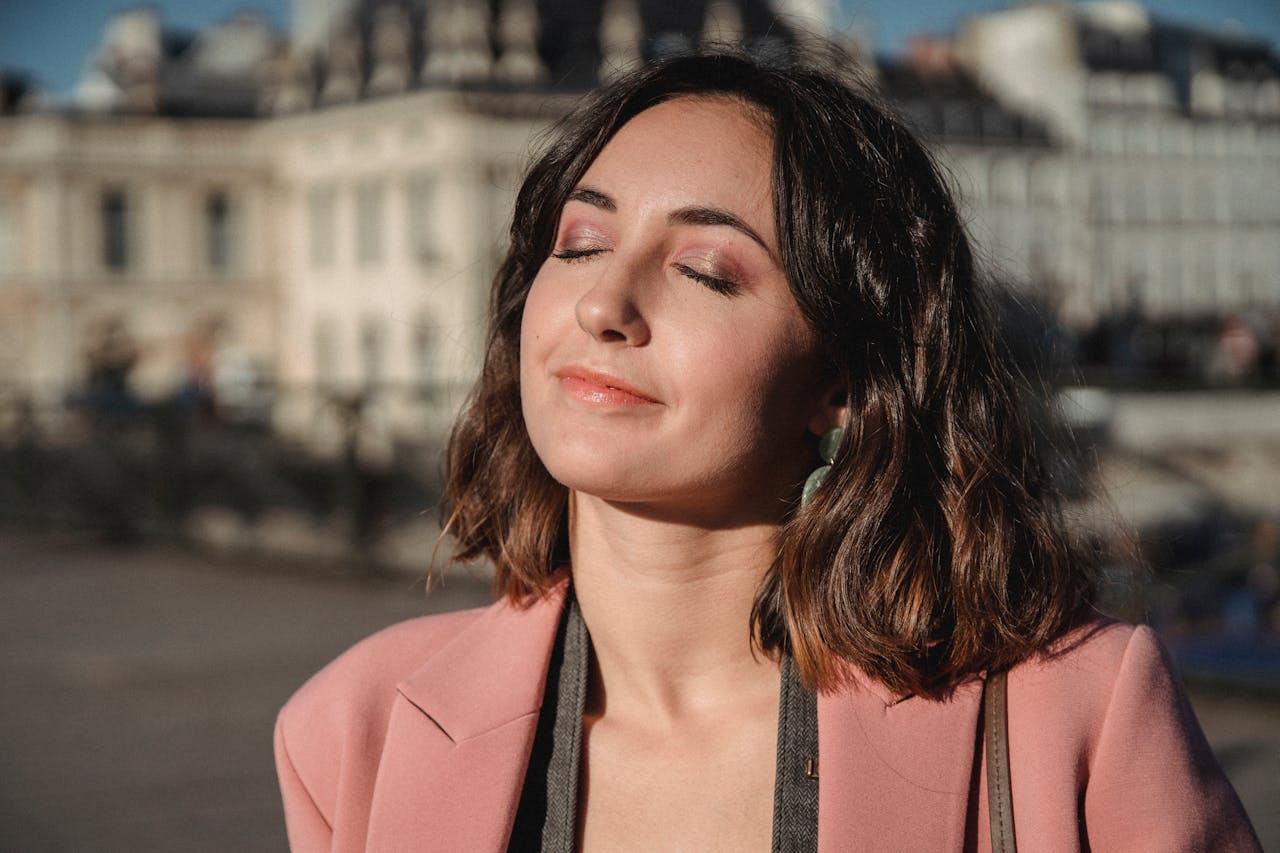 A woman enjoying the warmth of the sun on her face.