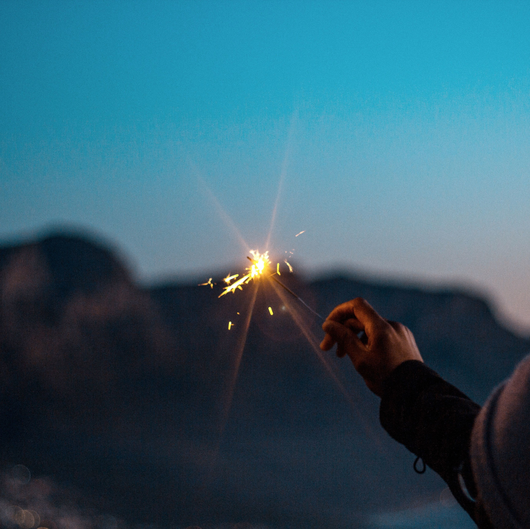202607_stimulus_sparkler_scale Holding a sparkler against the evening sky.